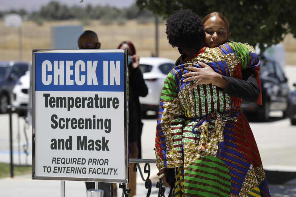 Mourners embrace during a funeral for Robert Fuller Tuesday, June 30, 2020, in Littlerock, Calif. Fuller, a 24-year-old Black man was found hanging from a tree in a park in a Southern California high desert city. Authorities initially said the death of Fuller appeared to be a suicide but protests led to further investigation, which continues. (AP Photo/Marcio Jose Sanchez)