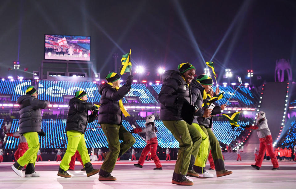 <p>Flag bearer Audra Segree of Jamaica and teammates wear bright green pants, black puffer jackets, and beanies with their nation’s flag on them while entering the stadium during the opening ceremony of the 2018 PyeongChang Games. (Photo: Matthias Hangst/Getty Images) </p>