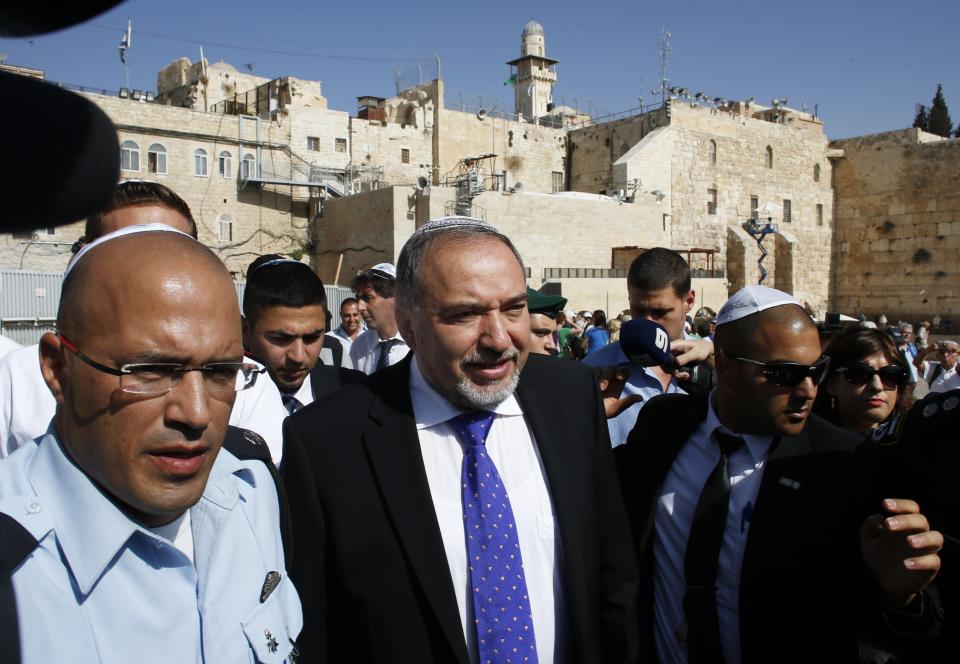 Former Israeli Foreign Minister Avigdor Lieberman (C) leaves after praying at the Western Wall, Judaism's holiest site, in Jerusalem's Old City, following his acquittal in a corruption trial November 6, 2013. Israeli Prime Minister Benjamin Netanyahu welcomed Lieberman back to government on Wednesday after the ultra-nationalist politician was acquitted of corruption charges. REUTERS/Ronen Zvulun (JERUSALEM - Tags: POLITICS CRIME LAW RELIGION)