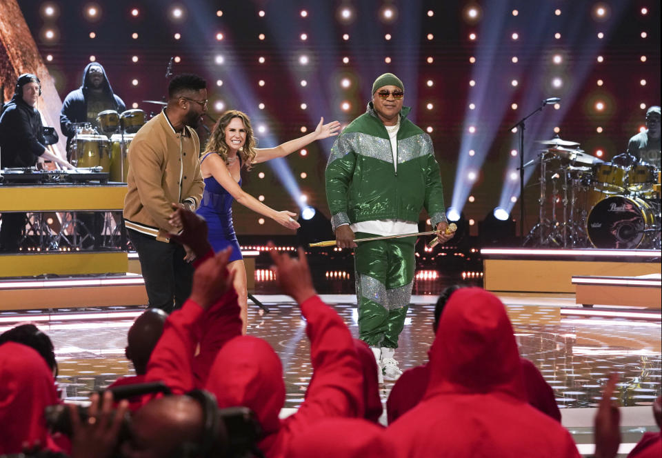 This image provided by CBS shows LL Cool J, right, and hosts Nate Burleson, from left, and Keltie Knight during an episode of the television game show "Superfan." (Sonja Flemming/CBS via AP)