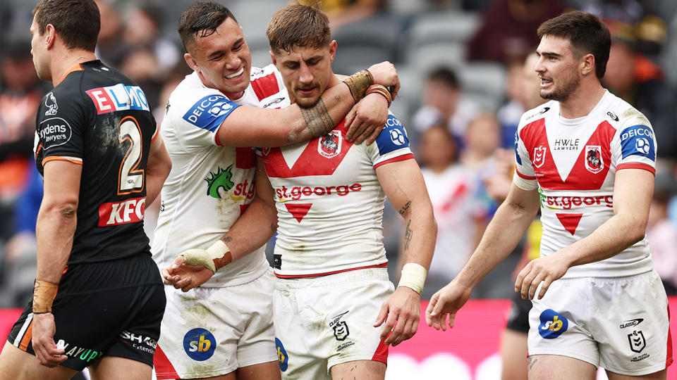 Zac Lomax is embraced by Dragons teammates after a crucial try against the Wests Tigers.