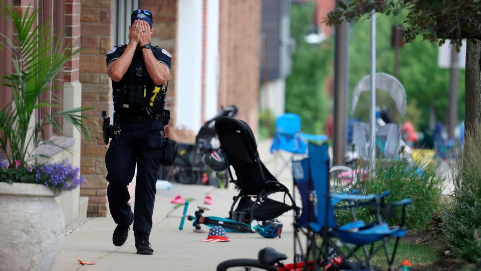 A police officer walks down Central Avenue in Highland Park, Illinois, on July 4, 2022, after a shooter opened fire at the Fourth of July parade. - Brian Cassella/AP