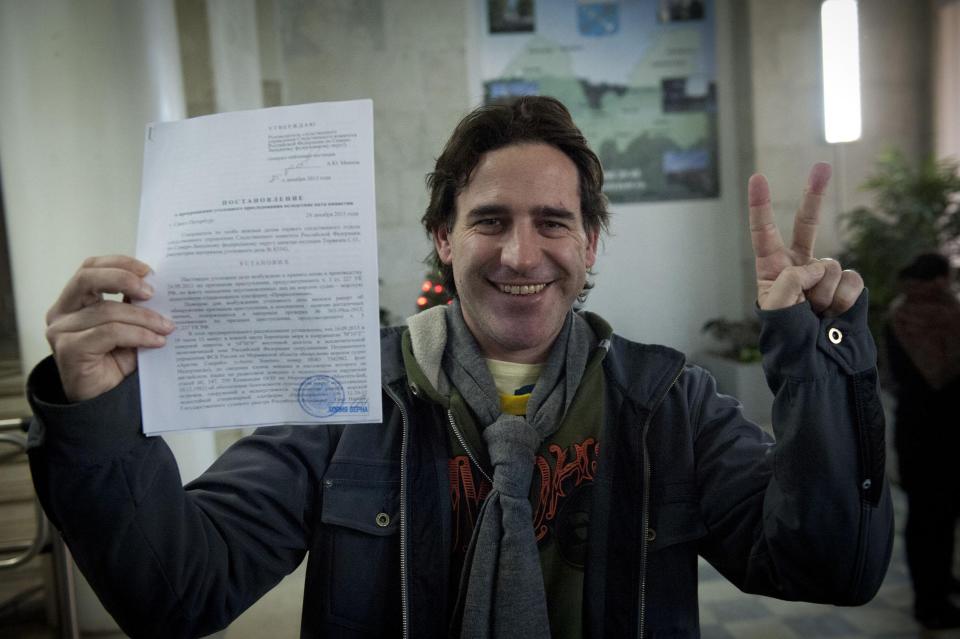 Greenpeace handout shows Greenpeace International activist Perez Orsi holding up papers certifying termination of his criminal prosecution, after having criminal charges against him dropped, in Saint Petersburg