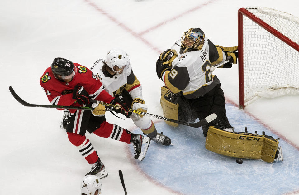 Vegas Golden Knights goalie Marc-Andre Fleury (29) makes the save on Chicago Blackhawks' Drake Caggiula (91) as Zach Whitecloud (2) defends during the third period of an NHL hockey Stanley Cup first-round playoff series, Saturday, Aug. 15, 2020, in Edmonton, Alberta. (Jason Franson/The Canadian Press via AP)