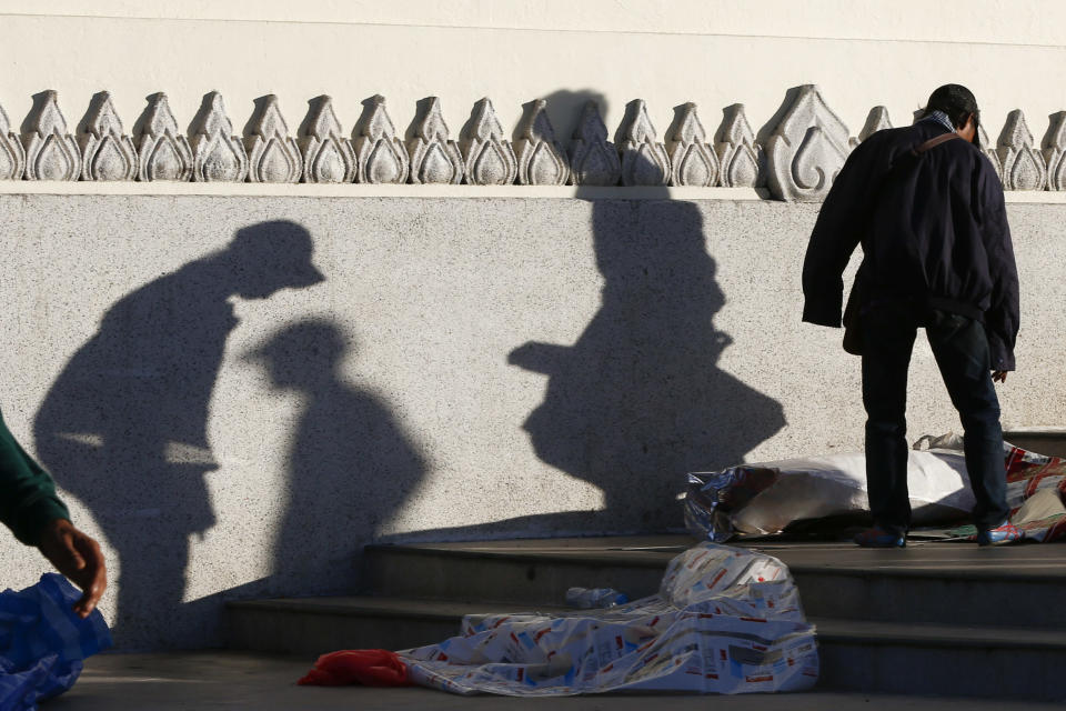 Volunteers from anti-government protesters clean up after an overnight shooting attack at Democracy Monument in Bangkok, Thailand, Thursday, May 15, 2014. Explosions and the overnight shooting attack on opposition demonstrators in Thailand’s capital killed at least two people Thursday, the latest violence to hit Bangkok since protesters launched a campaign to oust the government six months ago. (AP Photo/Vincent Thian)