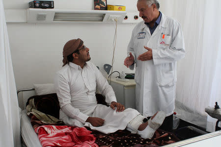 Abdallah, 29, who lost his right leg after an explosion in Yemen, sits in a hospital bed as he speaks with a counselor inside a Medecins Sans Frontieres hospital in Amman, Jordan, November 20, 2016. Picture taken November 20, 2016. Lin Taylor/Thomson Reuters Foundation via REUTERS