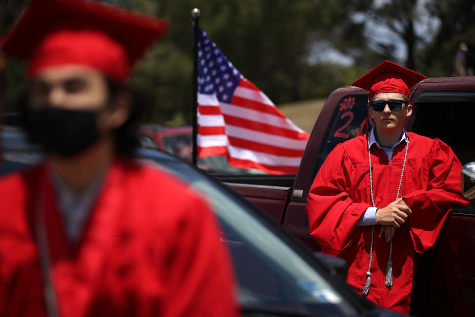 SAN RAFAEL, CALIFORNIA - JUNE 12: Redwood High School seniors look on during a drive-in graduation ceremony at the Marin County Fairgrounds on June 12, 2020 in San Francisco, California. Due to the coronavirus COVID-19 pandemic, Redwood High School graduating seniors had a drive-in ceremony where graduates had to practice social distancing and remain in or immediately around their vehicles with their families.  (Photo by Justin Sullivan/Getty Images)