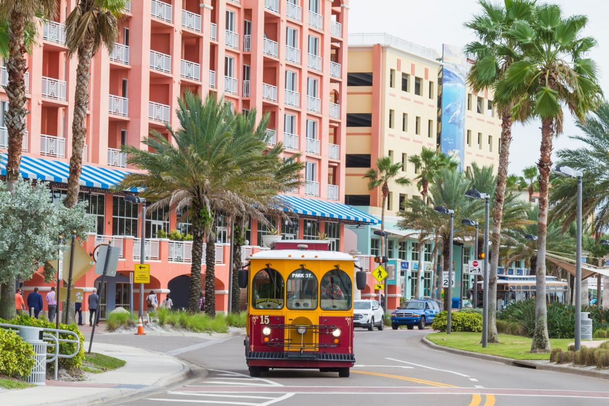 A general landscape view of Clearwater Beach, on main focus a recreated trolley bus, this kind of bus are the public transportation around the ClearWater City.