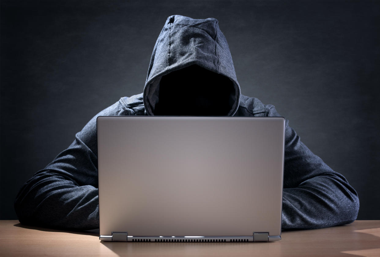 Hooded man at a laptop 