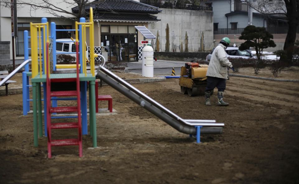 A man uses a roller near a Geiger counter, measuring a radiation level of 0.207 microsievert per hour, during nuclear radiation decontamination work at a park in Koriyama, west of the tsunami-crippled Fukushima Daiichi nuclear power plant, Fukushima prefecture February 27, 2014. (REUTERS/Toru Hanai)