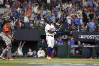 Texas Rangers' Adolis Garcia, right, watches his three-run home run along with Houston Astros catcher Martin Maldonado during the sixth inning in Game 5 of the baseball American League Championship Series Friday, Oct. 20, 2023, in Arlington, Texas. (AP Photo/Julio Cortez)