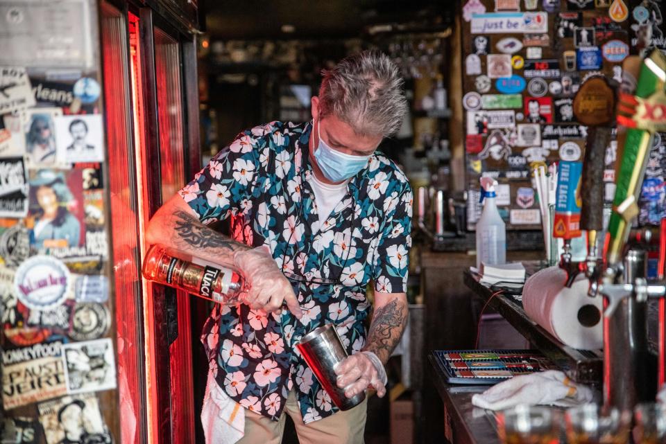 A bartender wearing a facemask makes a drink at a restaurant in Austin, Texas, June 26, 2020.  / Credit: SERGIO FLORES/AFP via Getty Images