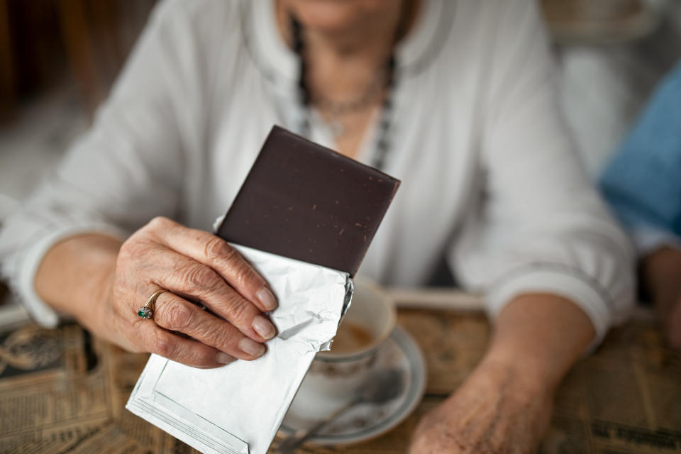 Senior woman eating chocolate. (Getty Images)