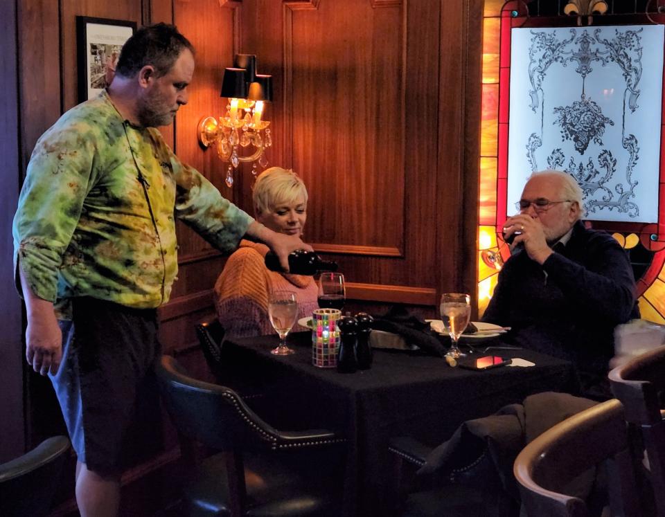 Bill Hughes, chef and owner of the Cupola Club, pours wine for guests at The Cupola Club on Tuesday, March 29, 2022.