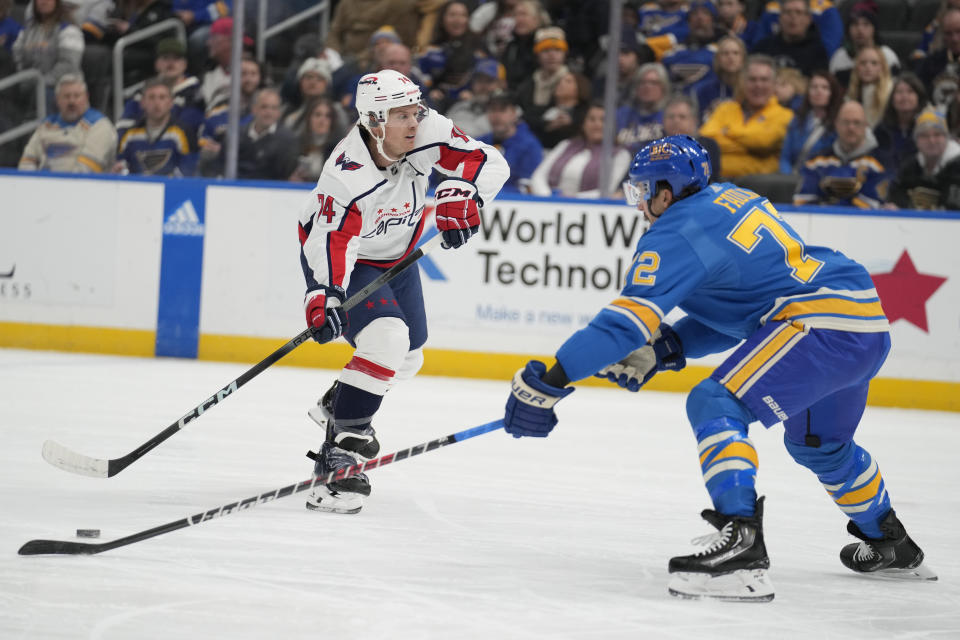 Washington Capitals' John Carlson (74) passes around St. Louis Blues' Justin Faulk (72) during the first period of an NHL hockey game Saturday, Jan. 20, 2024, in St. Louis. (AP Photo/Jeff Roberson)