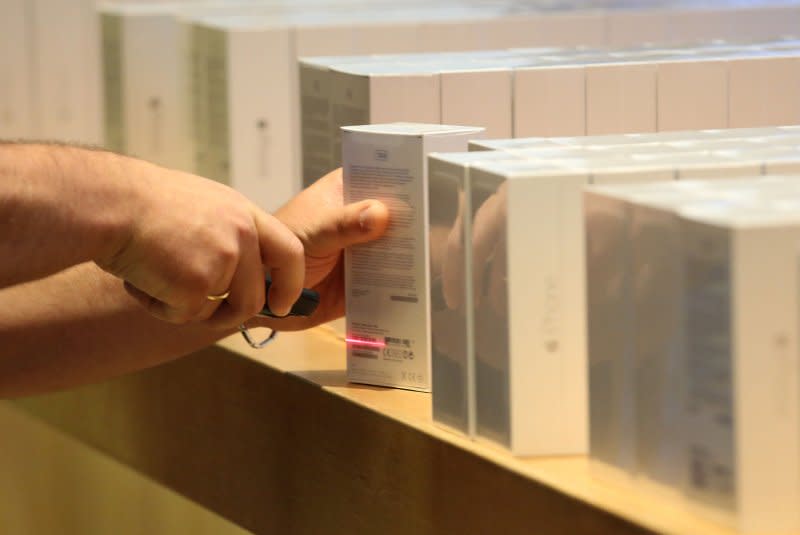An Apple employee scans a box containing an iPhone 6 at the Apple Store near Place de l'Opera in Paris on September 19, 2014. On June 26, 1974, the barcode, allowing for the electronic scanning of prices, was used for the first time. File Photo by David Silpa/UPI