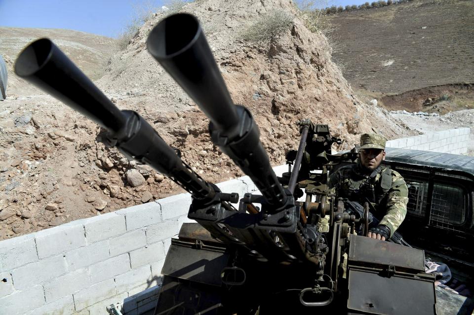 FILE -- In this Sunday, Sept. 9, 2018 file photo, fighters with the Free Syrian army patrol the outskirts of the northern town of Jisr al-Shughur, Syria, west of the city of Idlib. n two months of intensive airstrikes and bombardments on the rebel-controlled province of Idlib, Syrian government forces and their Russian allies have failed to make progress against battle-hardened insurgents. (Ugur Can/DHA via AP, File)