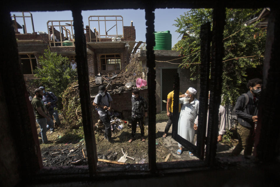 Kashmiris assemble outside a damaged house after a gunbattle in Srinagar, Indian controlled Kashmir, Thursday, Sept. 17, 2020. The gunfight erupted shortly after scores of counterinsurgency police and soldiers launched an operation based on a tip about the presence of militants in a Srinagar neighborhood, Pankaj Singh, an Indian paramilitary spokesman, said. (AP Photo/Mukhtar Khan)