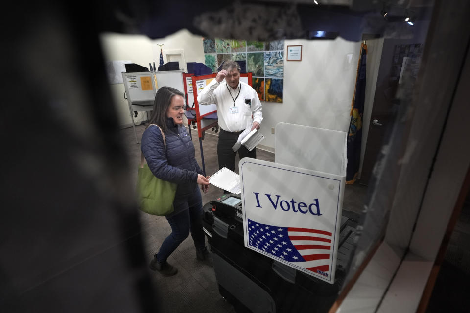 Amber Cutler casts her ballot as election official Monte Mason looks on during primary election voting Tuesday, March 5, 2024, at the town hall in Morrisville, Vt. (AP Photo/Robert F. Bukaty)