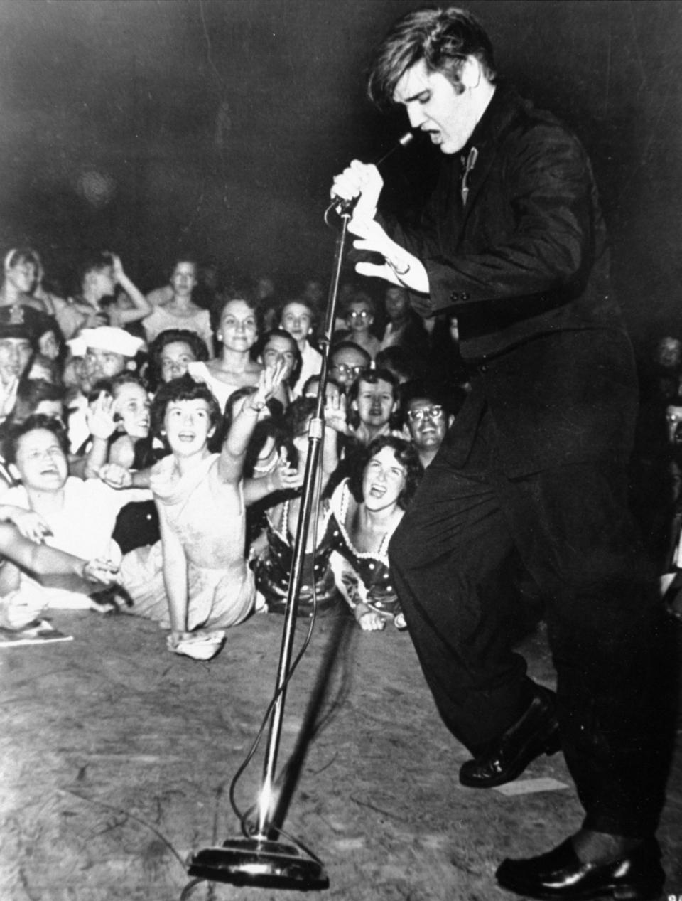 Elvis Presley shakes, rattles, and rolls as he performs in 1956.