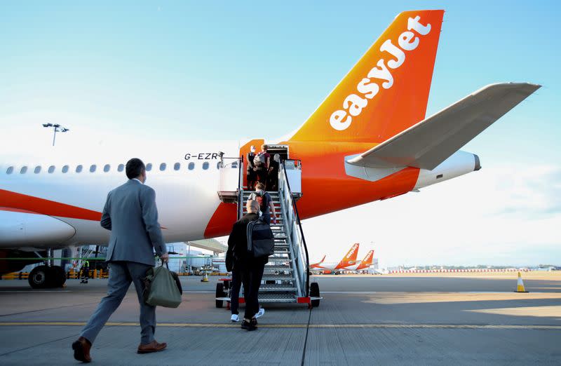 FILE PHOTO: Passengers board a plane as easyJet restarts its operations at Gatwick Airport