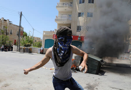 A Palestinian protester hurls stones towards Israeli troops during clashes following a protest in solidarity with Palestinian prisoners held by Israel, in the West Bank town of Bethlehem April 17, 2017. REUTERS/Ammar Awad TPX IMAGES OF THE DAY