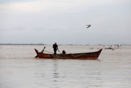 A fisherman operates his boat at the mouth of the Citarum river north-west of Muara Gembong, West Java province, Indonesia, February 22, 2018. REUTERS/Darren Whiteside