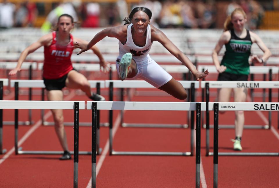 Buchtel's DaMya Barker races to a 14.33 seconds for a meet record first place finish in the Girls 100 meter hurdles at the Division II District Track and Field finals at Sebo Stadium in Salem on Saturday. Field's Hannah Siudak, left, finished in second and West Branch's Alexis Gregory, right, place fifth in the event.