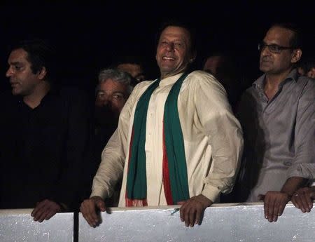 Imran Khan (C), cricketer-turned-opposition politician and chairman of the Pakistan Tehreek-e-Insaf (PTI) political party, smiles to his supporters after his speech during the fourth day of the Freedom March in Islamabad August 17, 2014. REUTERS/Faisal Mahmood