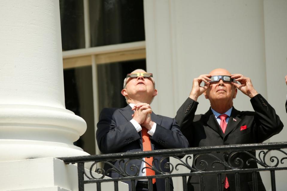 Attorney General Jeff Sessions and Commerce Secretary Wilbur Ross watch the eclipse from the Truman Balcony. (Photo: Kevin Lamarque/Reuters)