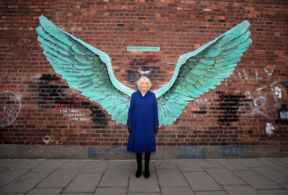 <p>The Duchess posed in front of a mural in Liverpool wearing a royal blue coat and black knee high boots. </p>