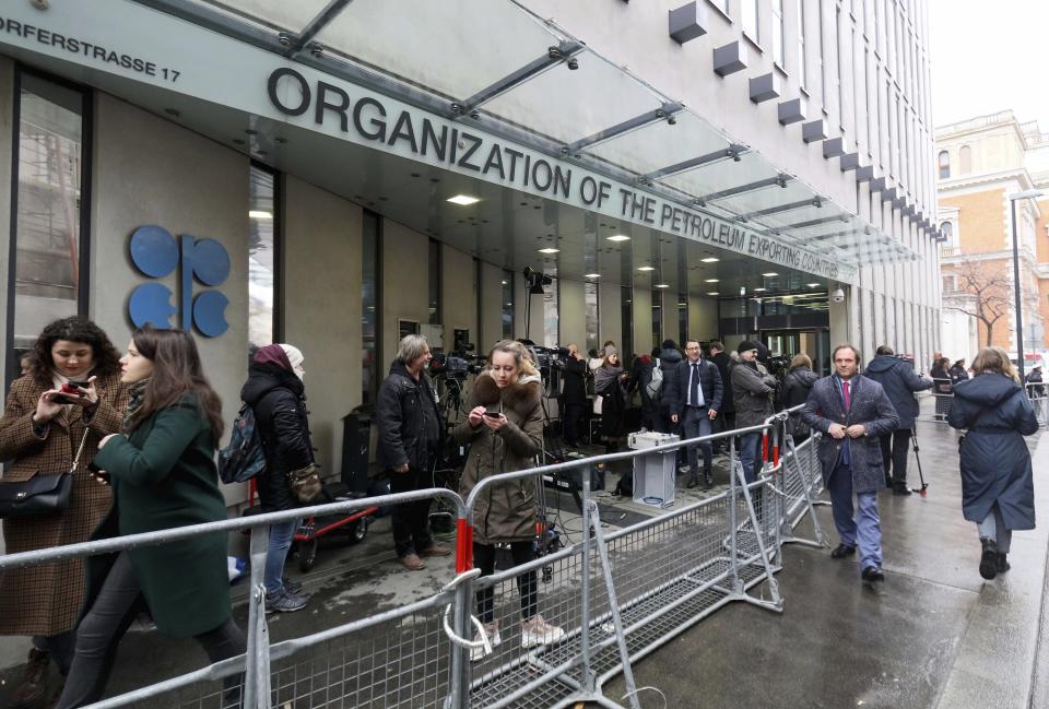 FILE - In this file photo dated Friday, March 6, 2020, before the coronavirus pandemic restrictions, people stand outside the headquarters of the Organization of the Petroleum Exporting Countries, OPEC, in Vienna, Austria. Members of oil producer cartel OPEC and allied countries are meeting online Thursday March 4, 2021, considering a possible increase in production now that prices have recovered to near their pre-pandemic levels. (AP Photo/Ronald Zak, FILE)