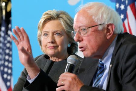 U.S. Democratic presidential nominee Hillary Clinton listens as U.S. Senator Bernie Sanders answers a question about college affordability during a campaign event at the University of New Hampshire in Durham, New Hampshire, United States September 28, 2016. REUTERS/Brian Snyder