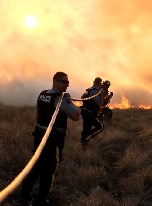 A file photo of RCMP officers helping to fight a wildfire. 