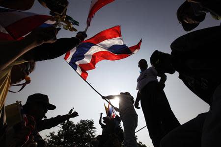 Anti-government protesters wave a Thai national flag as they celebrate atop a concrete barricade outside the Government House in Bangkok December 9, 2013. REUTERS/Kerek Wongsa