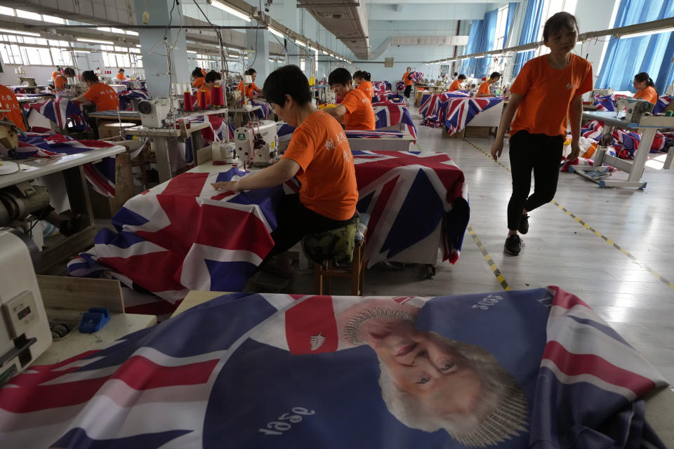 Workers produce British flags at the Shaoxing Chuangdong Tour Articles Co factory in Shaoxing, in eastern China's Zhejiang province, Friday, Sept. 16, 2022. Ninety minutes after Queen Elizabeth II died, orders for thousands of British flags started to flood into the factory south of Shanghai. (AP Photo/Ng Han Guan)