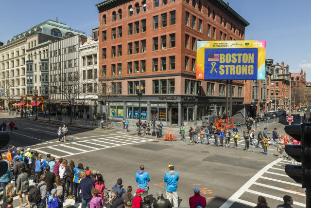 Boston Red Sox's Jonny Gomes places the championship trophy and a Red Sox  baseball jersey at the Boston Marathon Finish Line during a pause in their  World Series victory rolling rally in