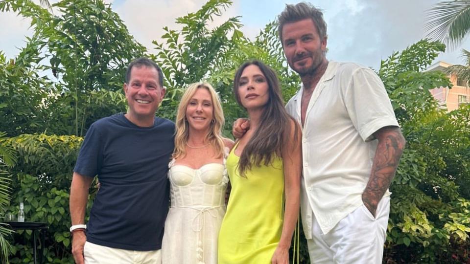 Victoria Beckham in a yellow-green slip dress with David Beckham and their friends