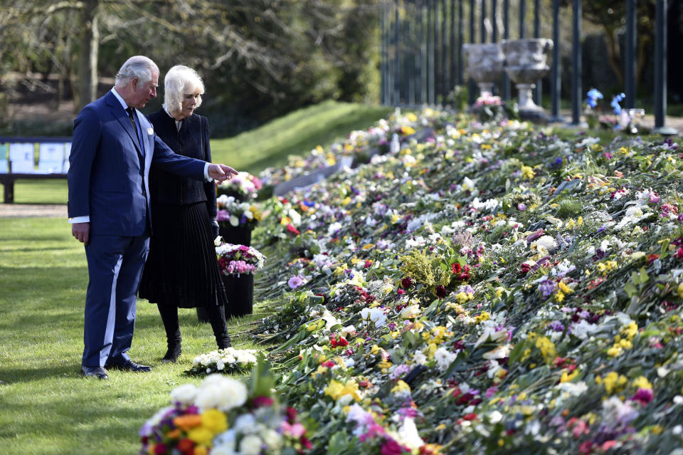 Britain's Prince Charles and Camilla, Duchess of Cornwall visit the gardens of Marlborough House, London, Thursday April 15, 2021, to look at the flowers and messages left by members of the public outside Buckingham Palace, following the death of Prince Philip. (Jeremy Selwyn/Pool via AP)