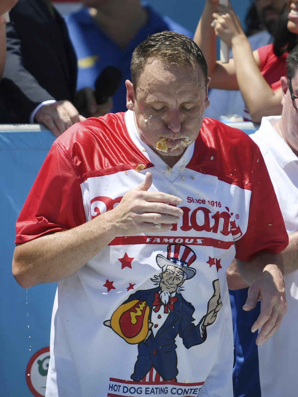 Joey Chestnut eats his 71st hot dog in the final seconds of the men's competition of Nathan's Famous July Fourth hot dog eating contest, Thursday, July 4, 2019, in New York's Coney Island. (AP Photo/Sarah Stier)