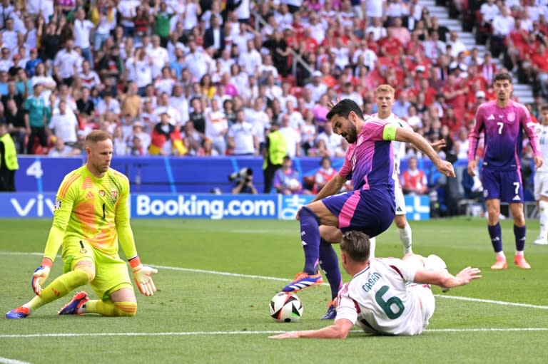 El alemán Ilkay Gundogan (centro) pugna un balón con el defensa húngaro Willi Orban en la acción del gol de Jamal Musiala durante la victoria por 2-0 de Alemania contra Hungría en la Eurocopa-2024, el 19 de junio de 2024 en Stuttgart. (DAMIEN MEYER)