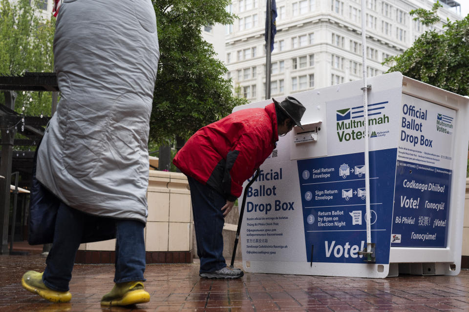 A person drops off a vote-by-mail ballot at a dropbox in Pioneer Square during primary voting on Tuesday, May 21, 2024, in Portland, Ore. (AP Photo/Jenny Kane)