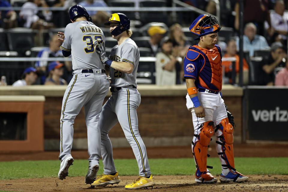 Milwaukee Brewers' Joey Wiemer, center, is congratulated by Jesse Winker (33) after hitting a two-run home run during the sixth inning of a baseball game as New York Mets catcher Francisco Alvarez, right, looks on Monday, June 26, 2023, in New York. (AP Photo/Adam Hunger)