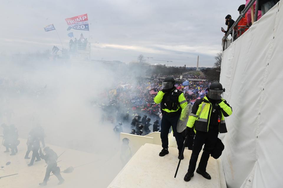 Police gather near tear gas as supporters of US President Donald Trump protest outside the US Capitol on January 6, 2021, in Washington, DC. - Demonstrators breeched security and entered the Capitol as Congress debated the a 2020 presidential election Electoral Vote Certification. (Photo by ROBERTO SCHMIDT / AFP) (Photo by ROBERTO SCHMIDT/AFP via Getty Images)