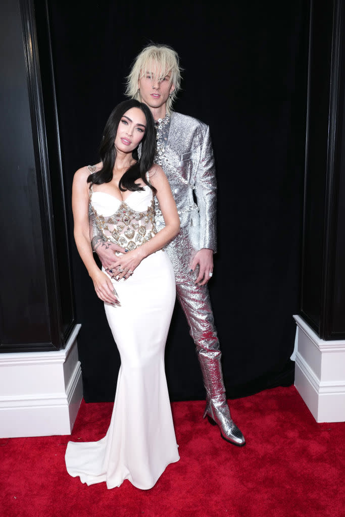 Megan Fox in body-hugging white gown and Machine Gun Kelly in silver suit.