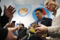 Democratic presidential candidate entrepreneur Andrew Yang signs books during a campaign event at the Wells Visitor Center & Ice Cream Parlor, Monday, Jan. 27, 2020, in Le Mars, Iowa. (AP Photo/John Locher)