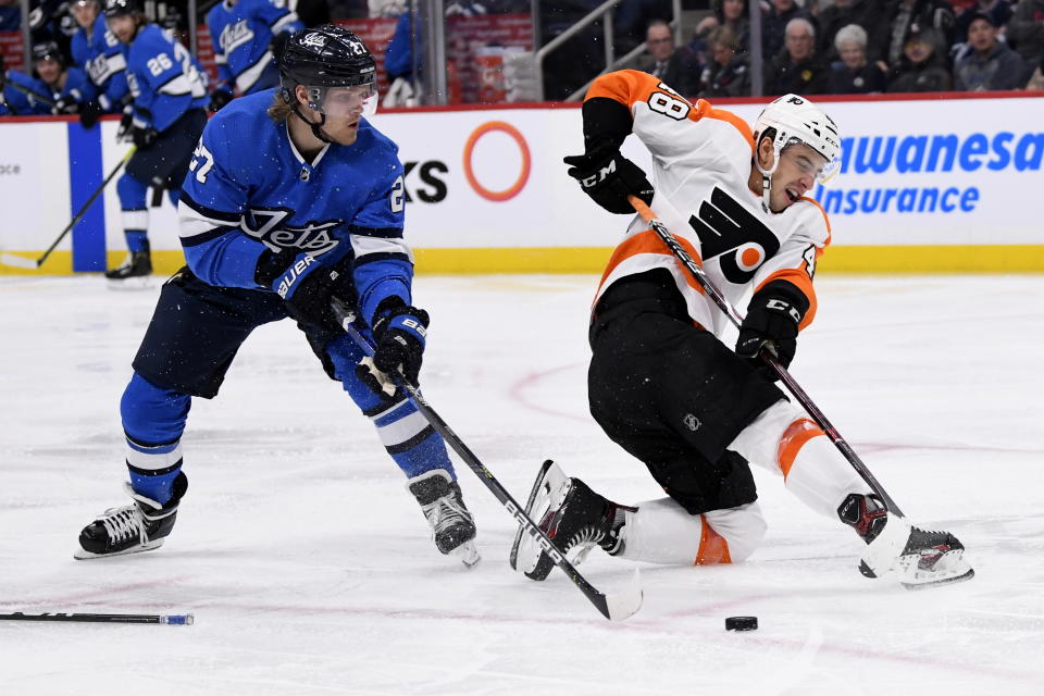 Philadelphia Flyers' Morgan Frost (48) clears the puck past Winnipeg Jets' Nikolaj Ehlers (27) during second period NHL hockey action in Winnipeg, Manitoba on Sunday Dec. 15, 2019. (Fred Greenslade/The Canadian Press via AP)