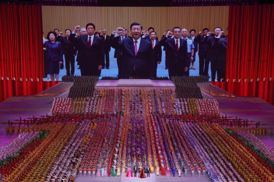 Xi Jinping again pictured centre on screen in front of a crowd of people.