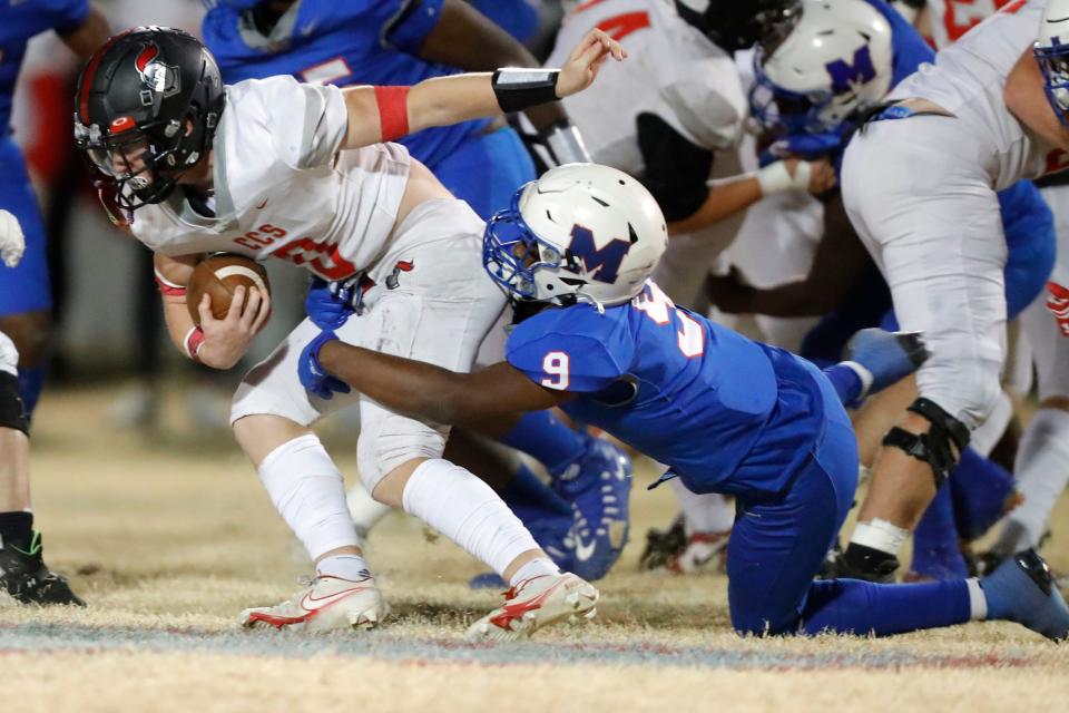 Crossings Christian's Holden Manchester is brought down by Millwood's Micho Lavine during a Class 2A first-round playoff game at Millwood in Oklahoma City on Nov. 10.