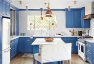 <p>Distract the eye from low ceilings with a bold blue paint color on kitchen cabinets. Polished silver hardware shines against doors painted in <a href="https://www.benjaminmoore.com/en-us/color-overview/find-your-color/color/HC-159/philipsburg-blue?color=HC-159" rel="nofollow noopener" target="_blank" data-ylk="slk:Philipsburg Blue by Benjamin Moore;elm:context_link;itc:0;sec:content-canvas" class="link ">Philipsburg Blue by Benjamin Moore</a>.</p>